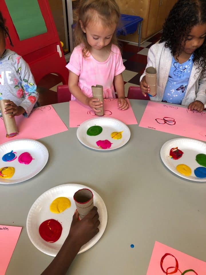 Children painting with cardboard tubes and colorful paints