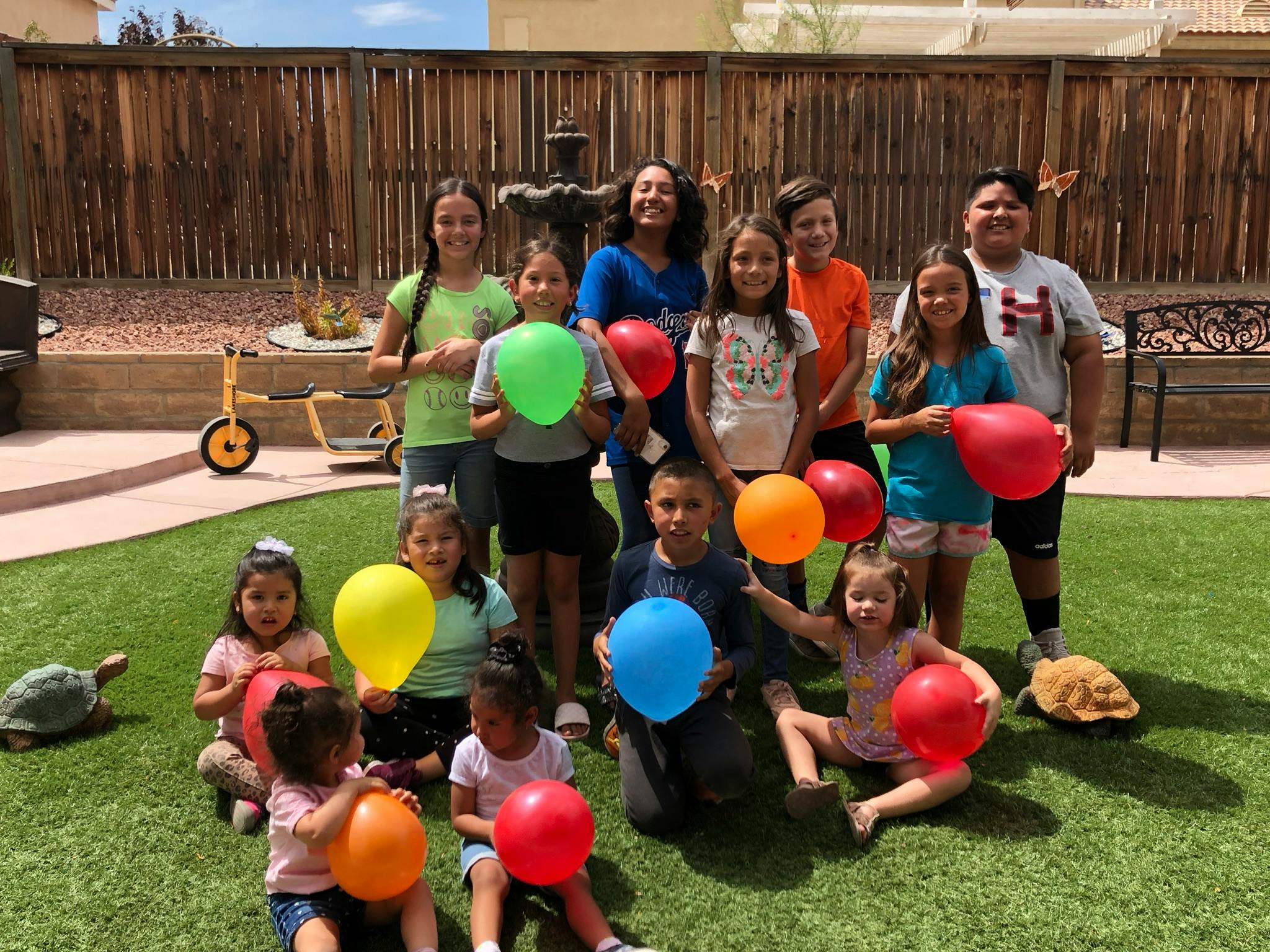 Group of adults and children holding balloons outdoors