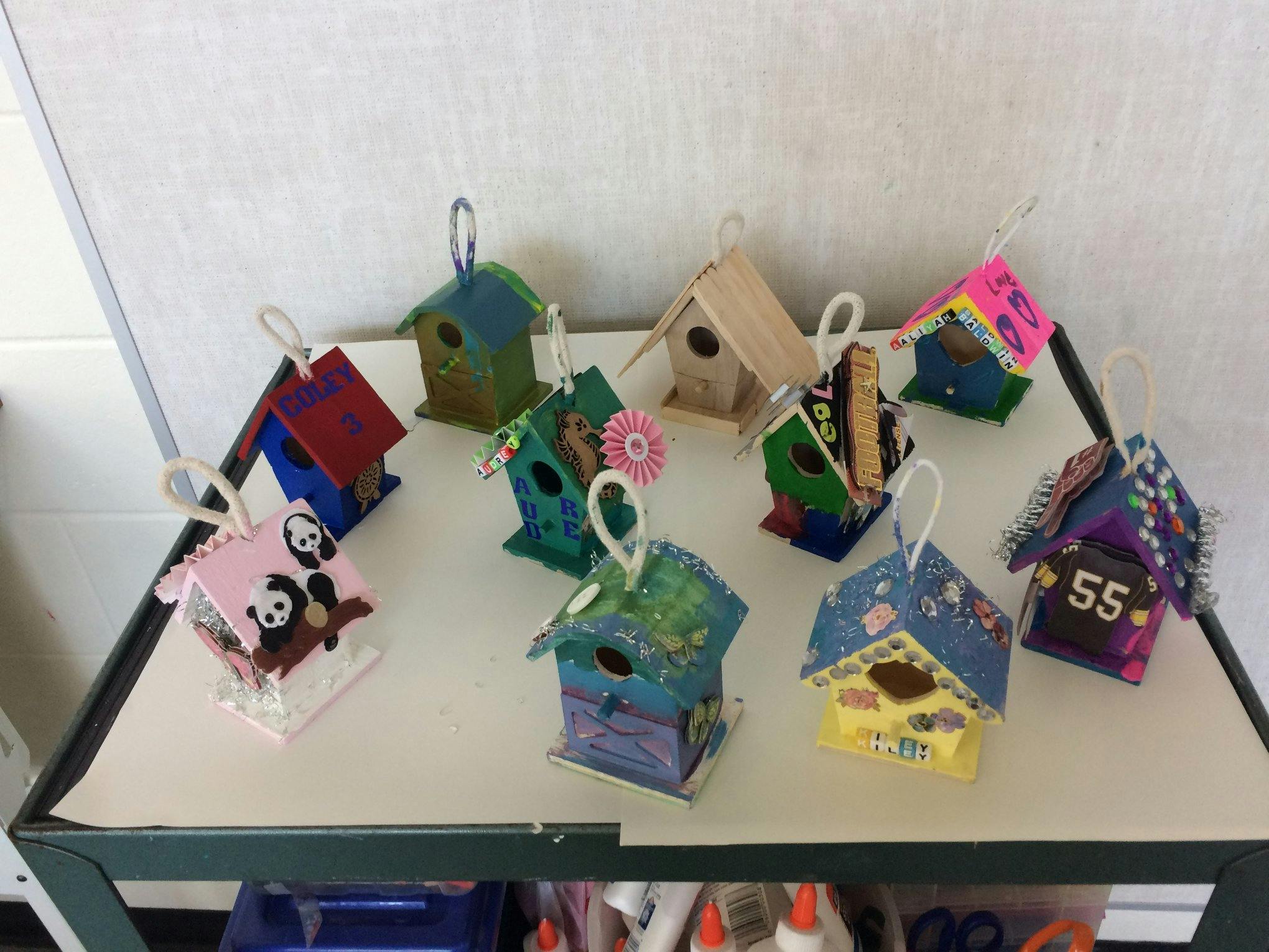 Collection of decorated miniature birdhouses on a table