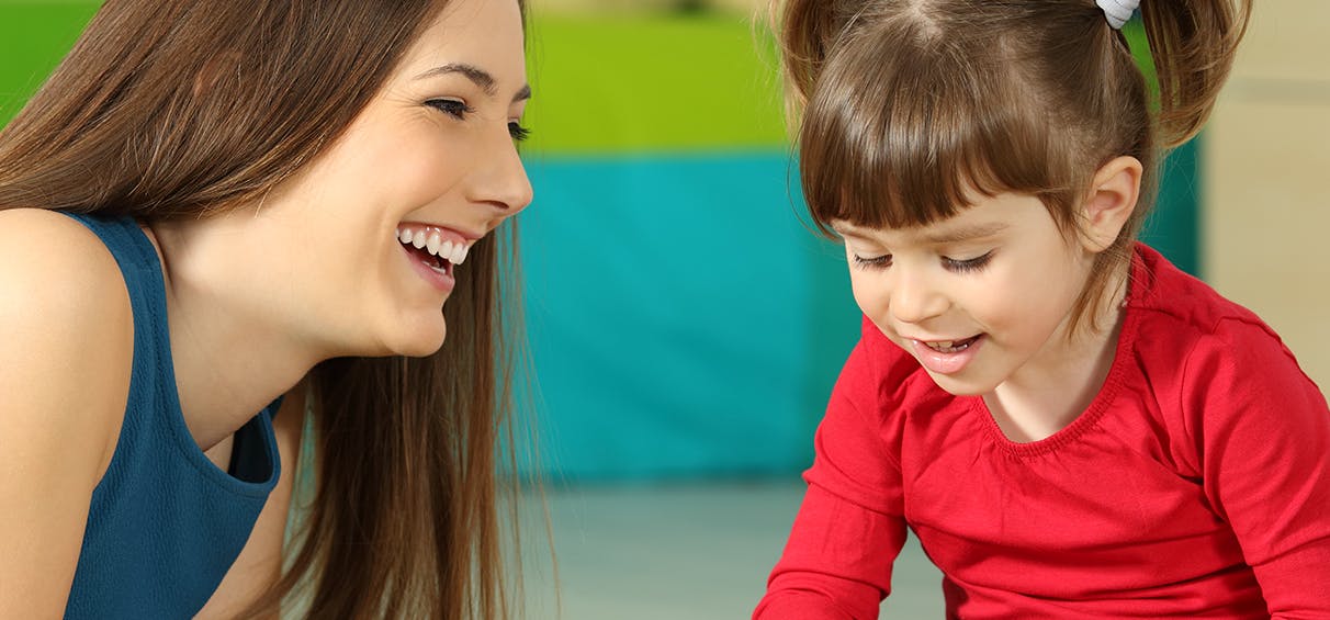 Adult person and child looking down and smiling