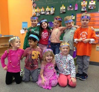 Group of children wearing crowns in a classroom