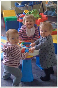 Three children playing with a toy table
