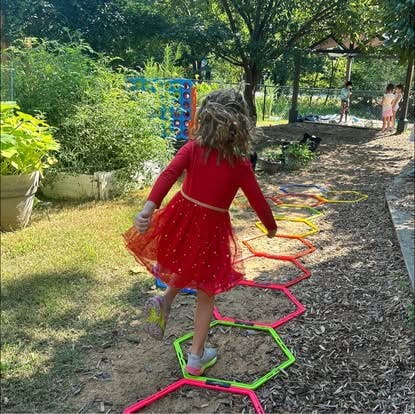 Child playing on an agility ladder in a backyard
