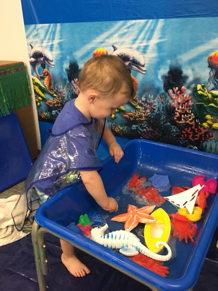 Child playing with water table toys