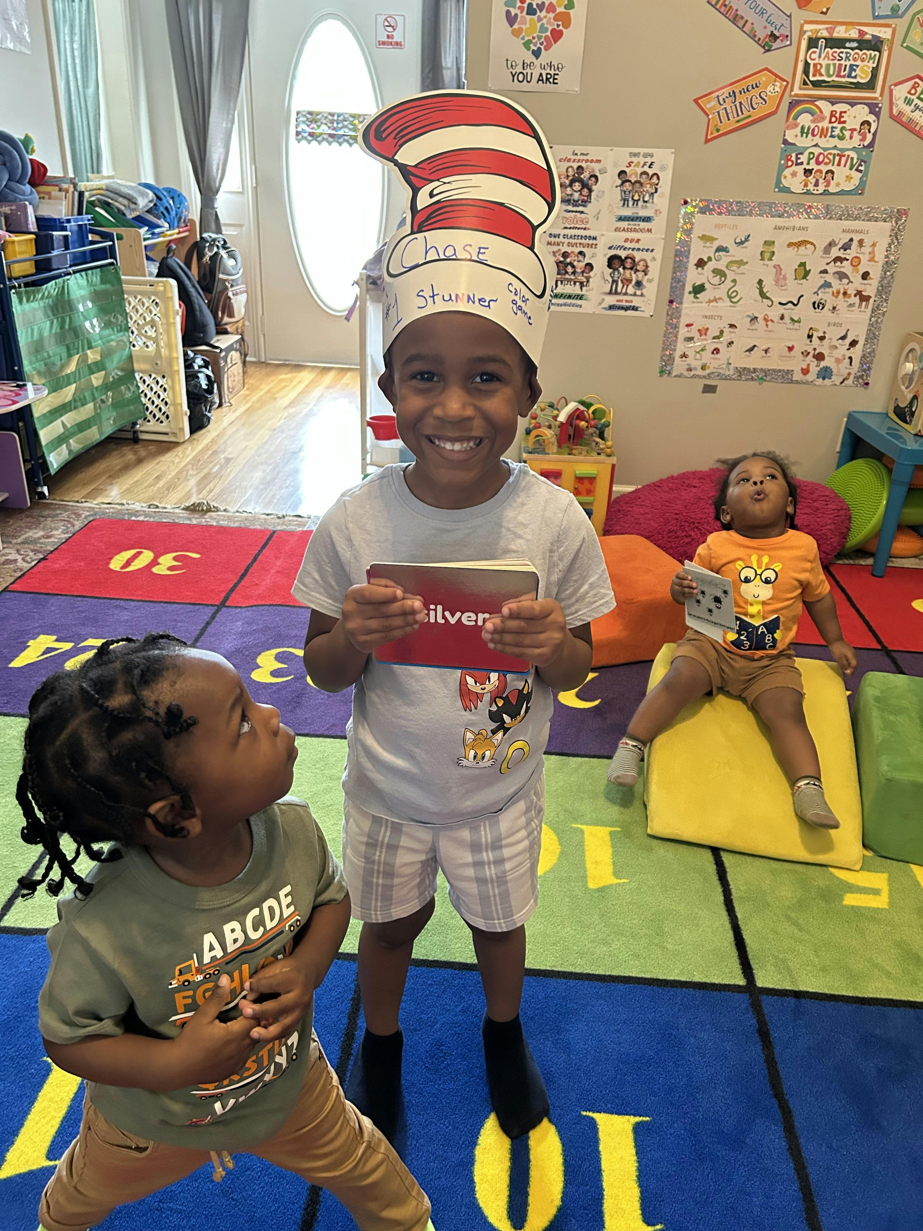Three children in a classroom playing with flashcards