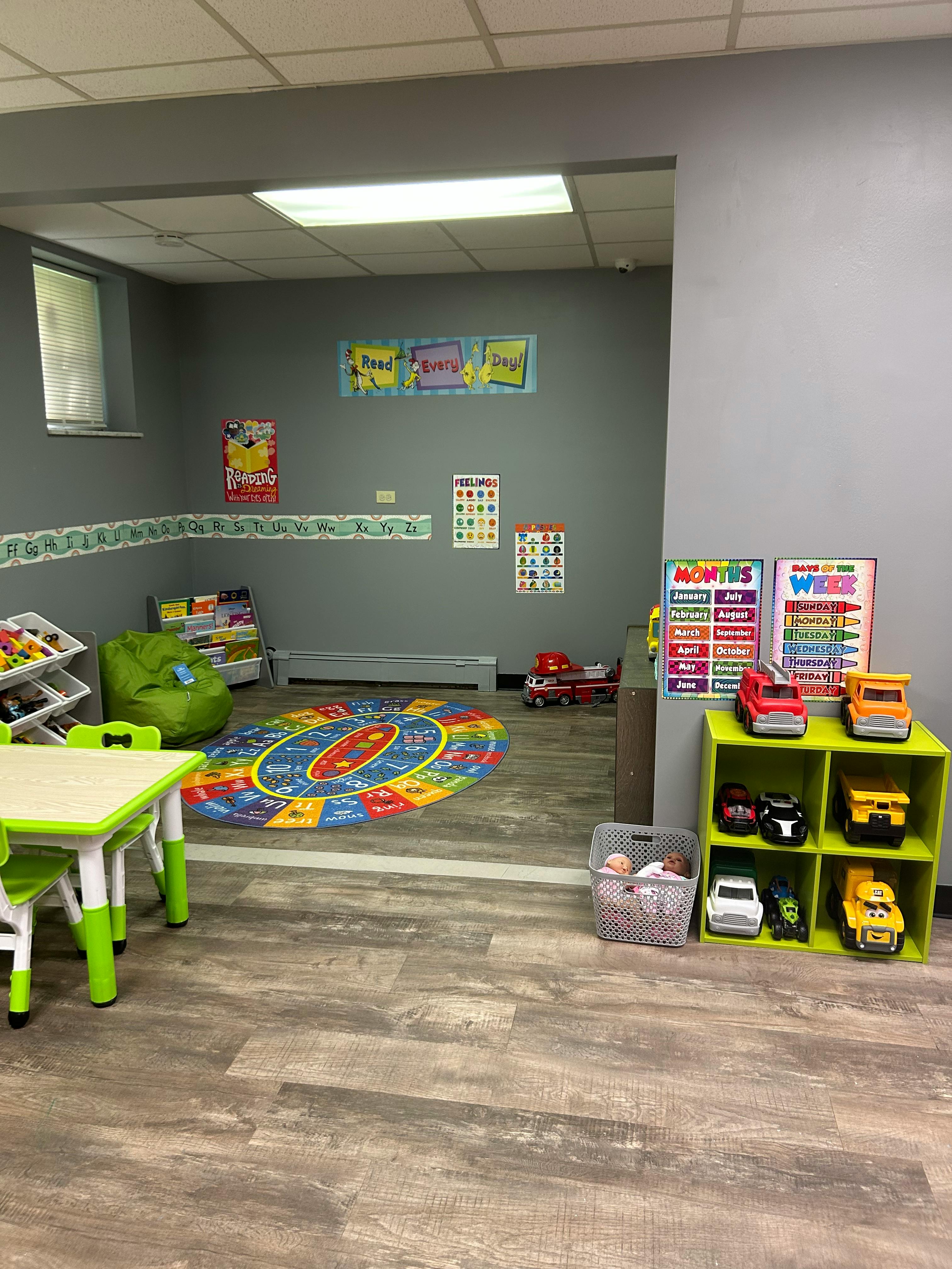Playroom with a colorful rug, small table and chairs, and toy storage