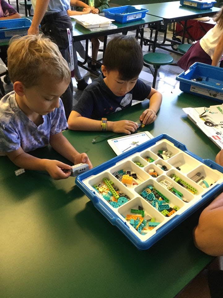 Two children building with colorful interlocking blocks at a table