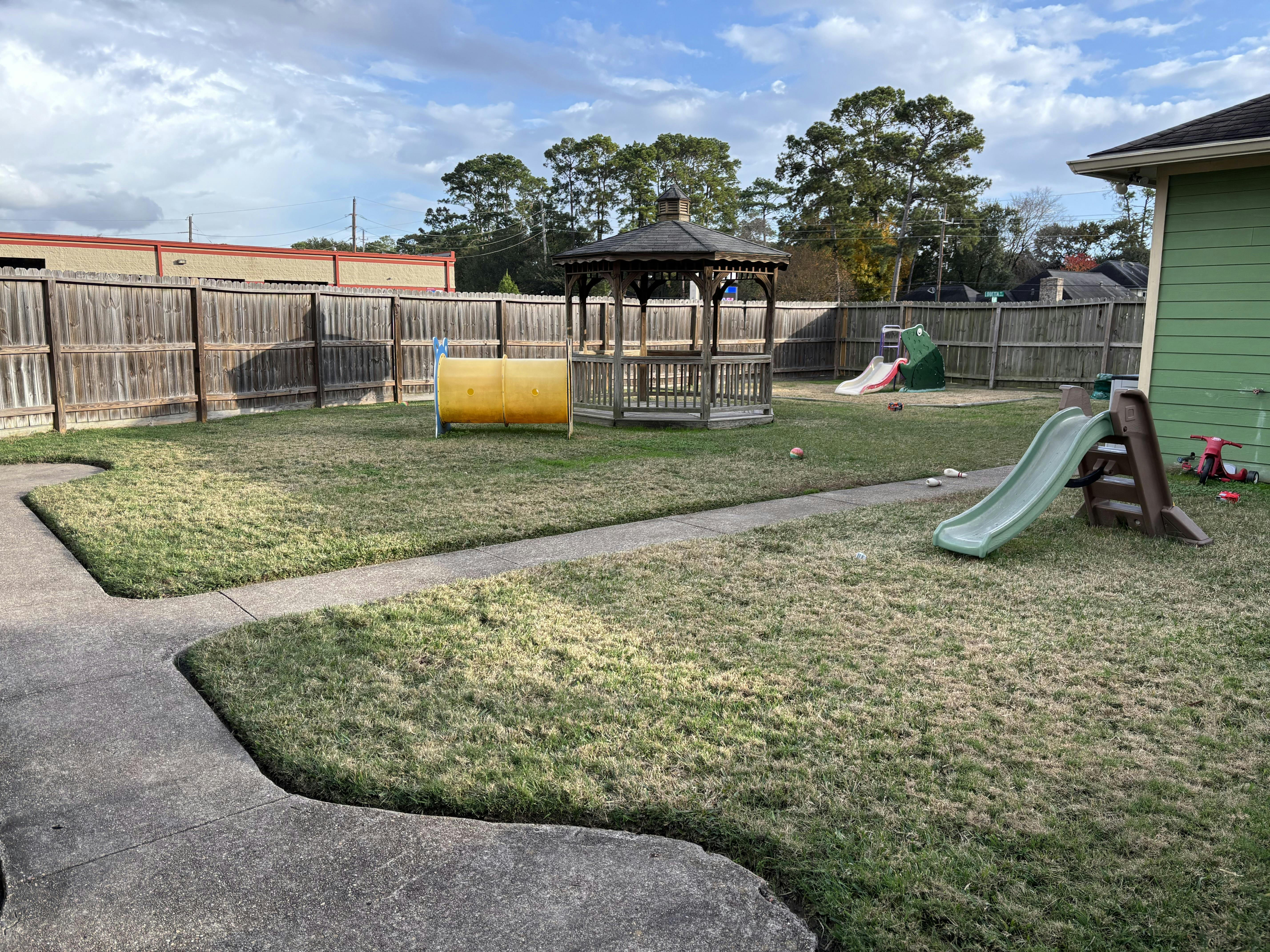 Outdoor play area with a gazebo, slides, and a yellow tunnel
