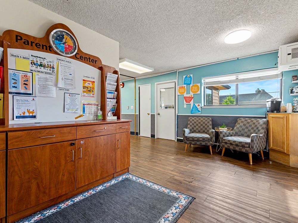 Parent Center sign above a wooden cabinet and two armchairs