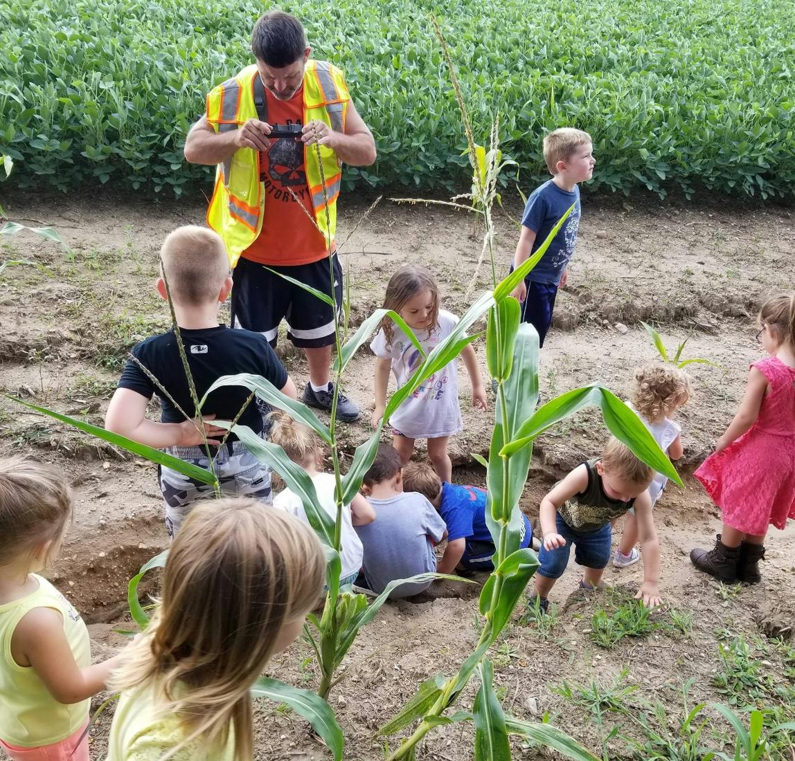 Person in safety vest with children in a field