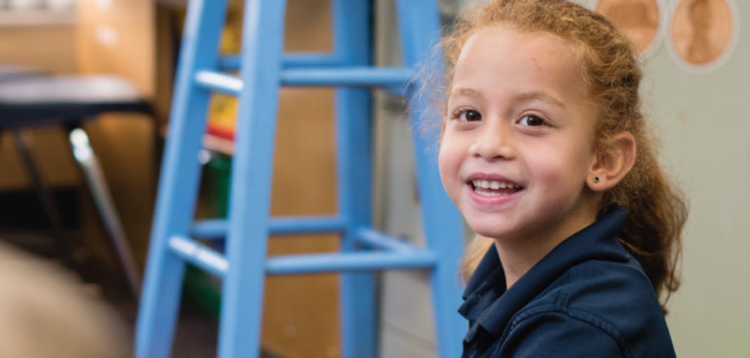 Child smiling in a classroom
