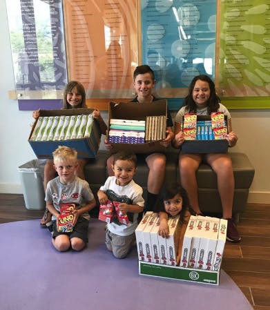 Children holding boxes of books and games