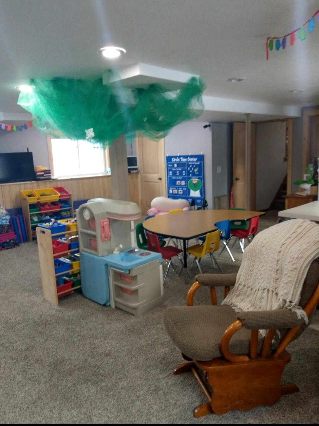 Playroom with a rocking chair, play kitchen, and children's table and chairs