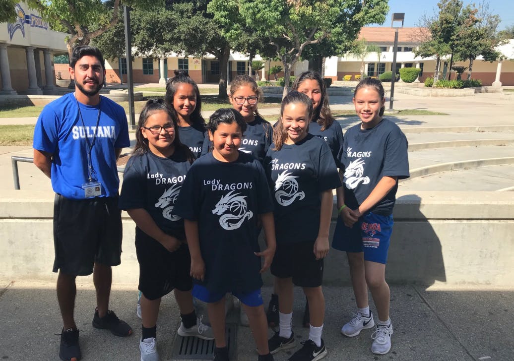Adult and group of children in matching shirts with "Dragons" shirts