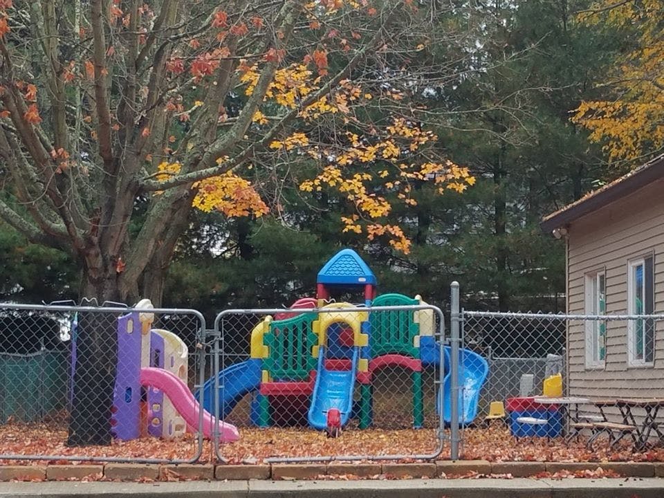 Playground with colorful slides and structures behind a chain-link fence
