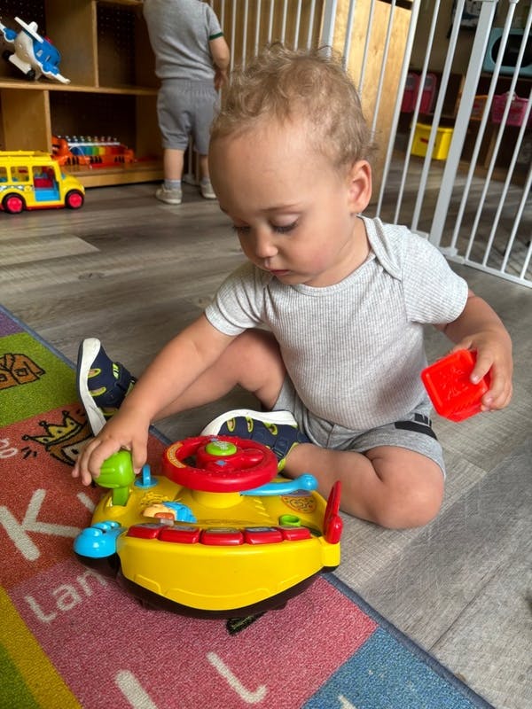 Child playing with a toy steering wheel