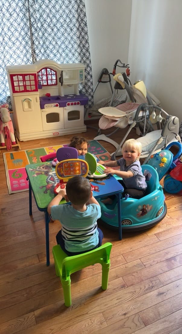 Three children playing with toys at a small table