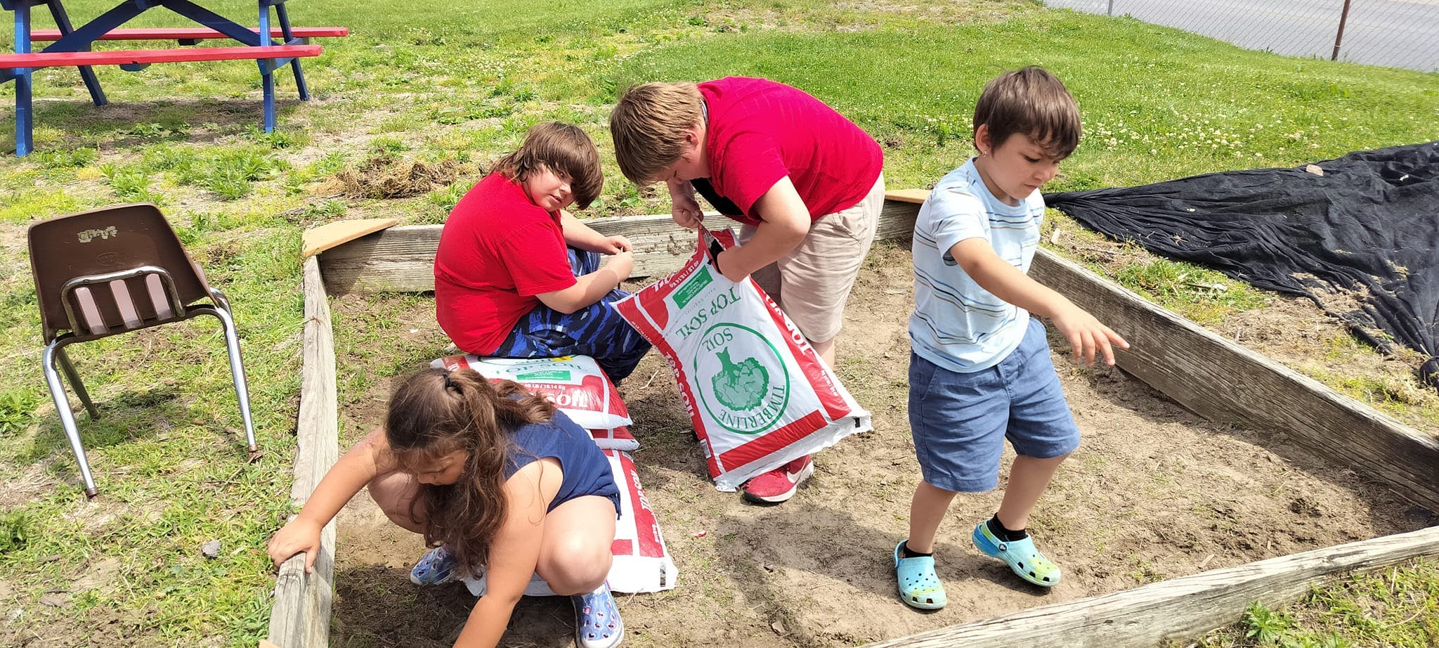Children working in a raised garden bed