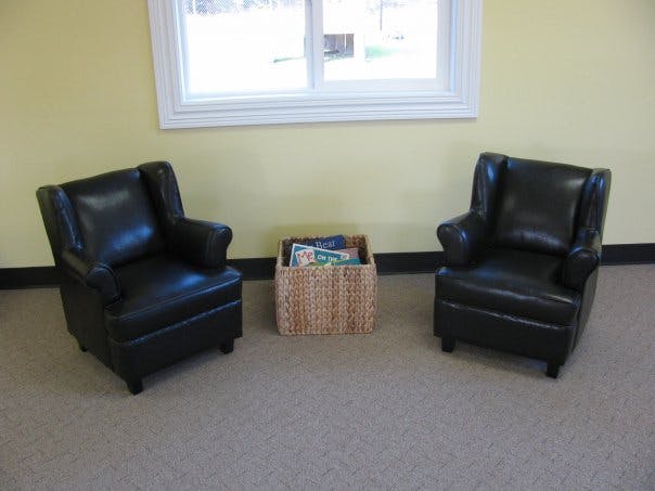 Two armchairs with a wicker basket of magazines between them