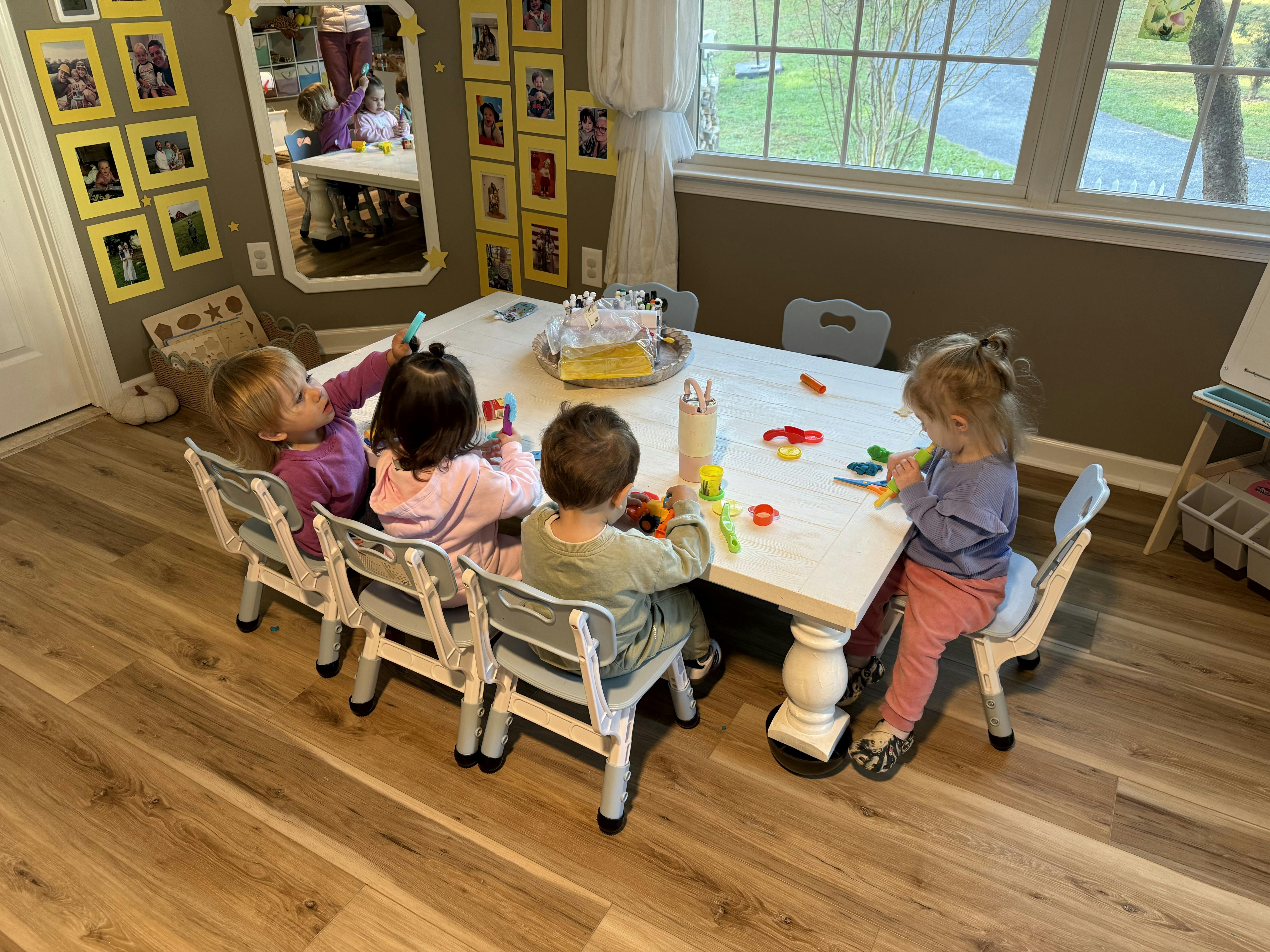 Four children sitting at a table with craft supplies