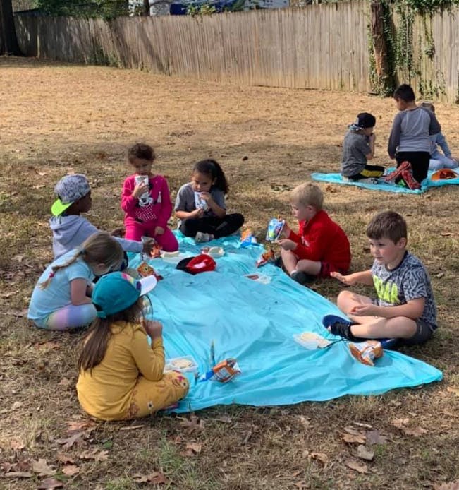Children sitting on blankets outdoors