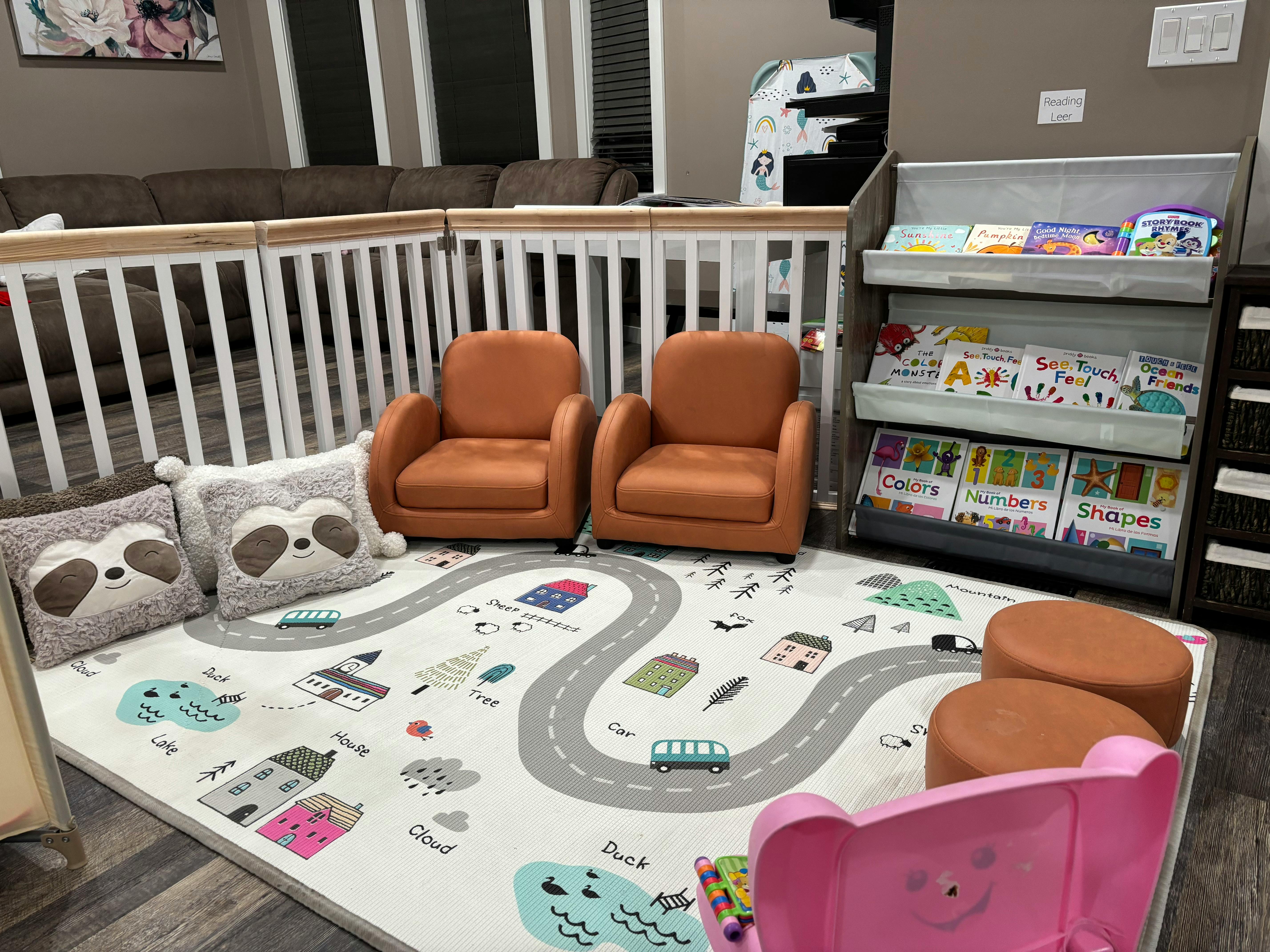 Playroom with two small chairs, a playmat, and a bookshelf
