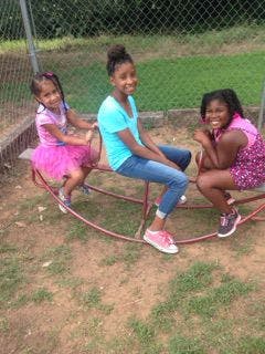 Three children on a playground seesaw
