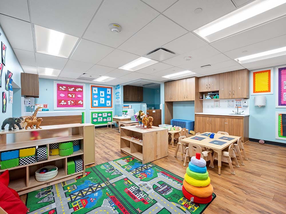 Empty children's classroom with small tables and chairs