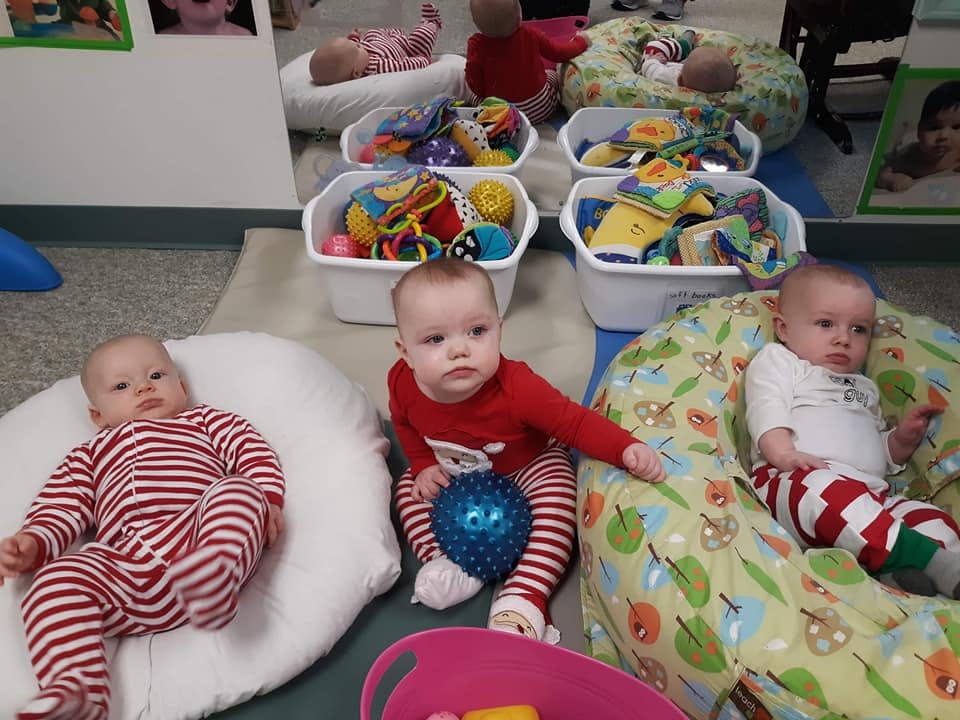 Three babies on the floor with toys