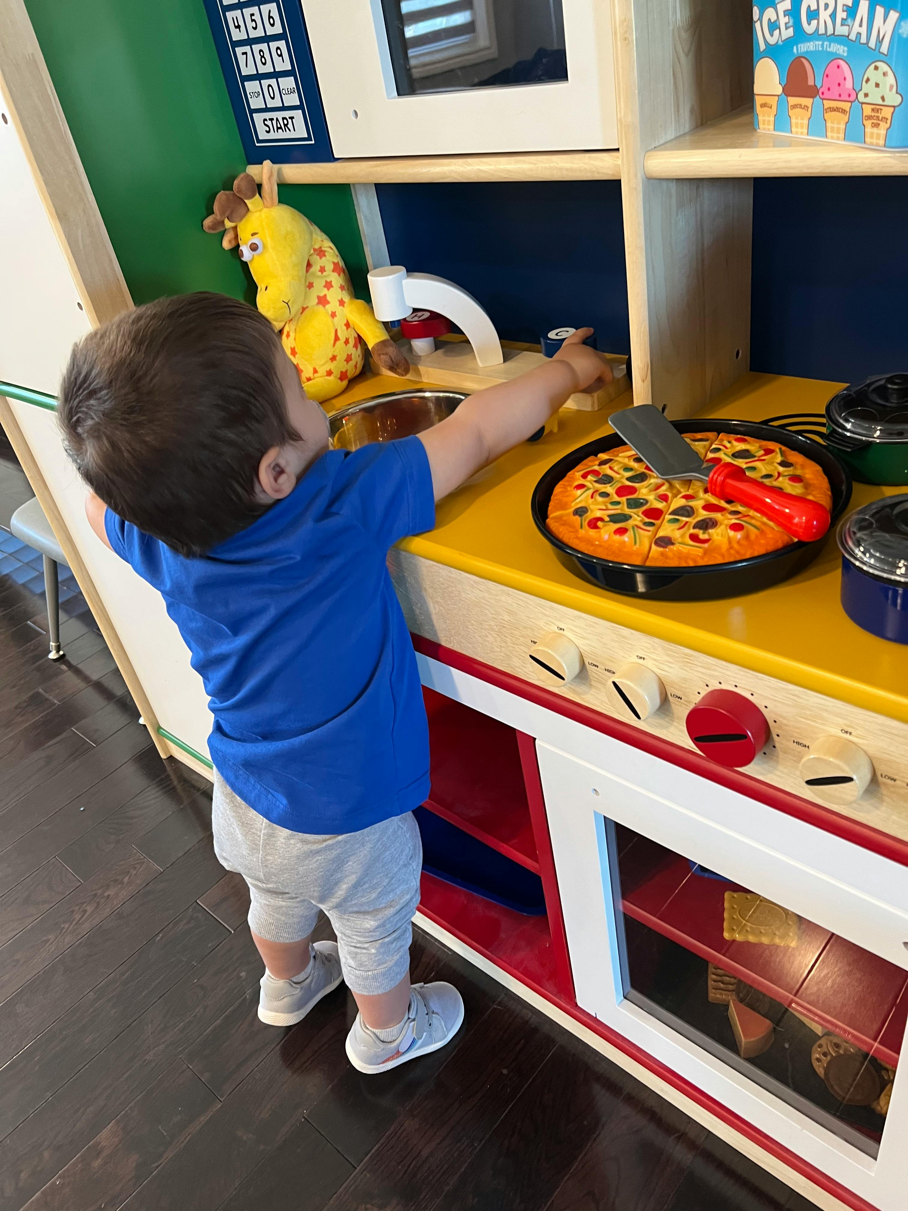 Child playing with a toy kitchen set