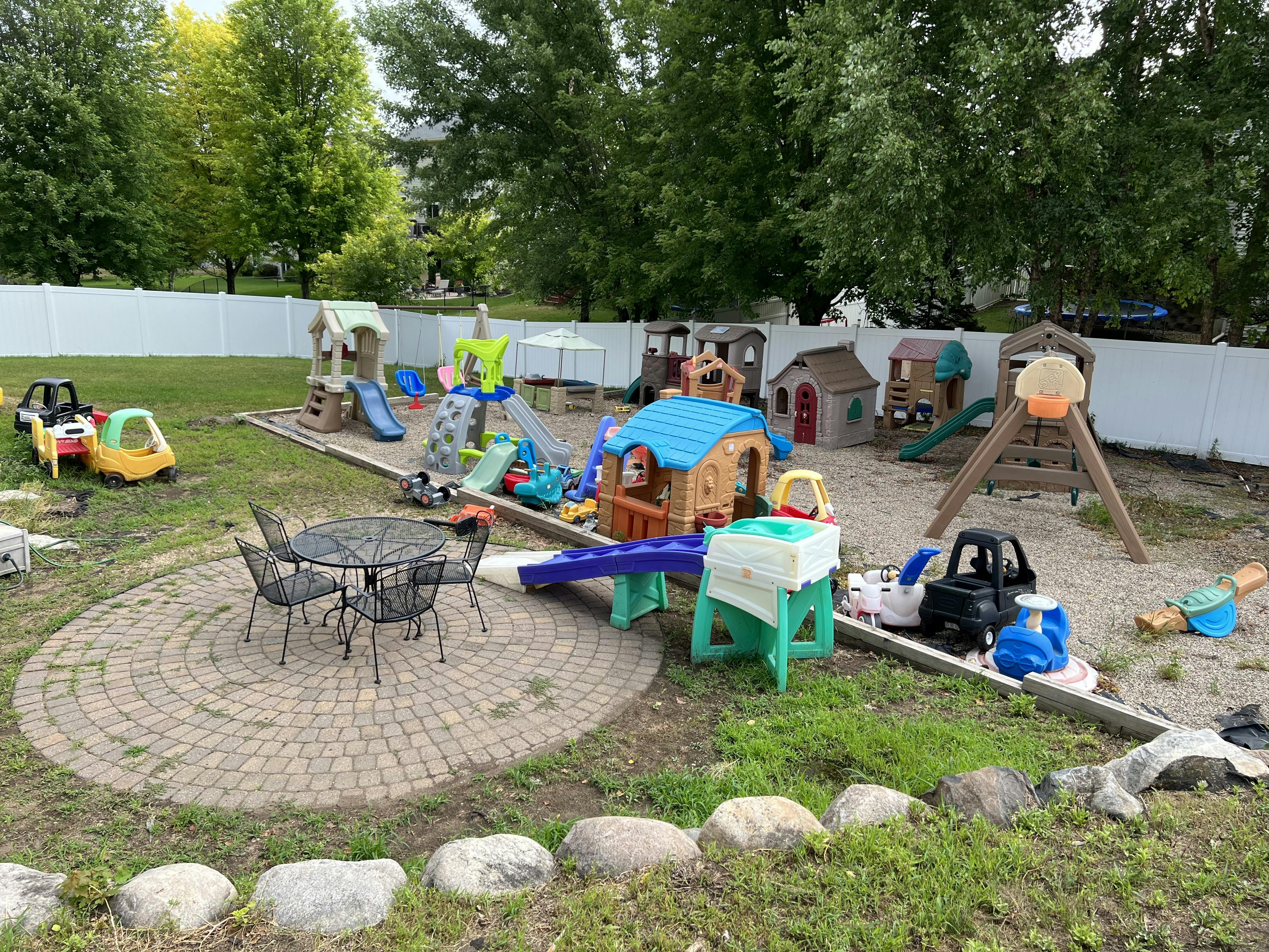Outdoor playground with various playhouses, slides, and toys