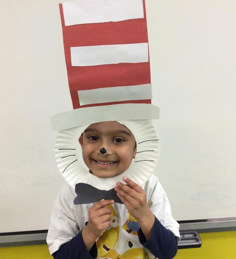 Child wearing a paper Cat in the Hat costume mask