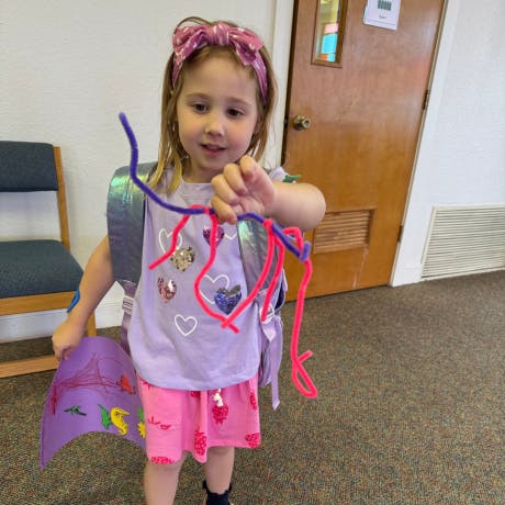 Child holding pipe cleaners