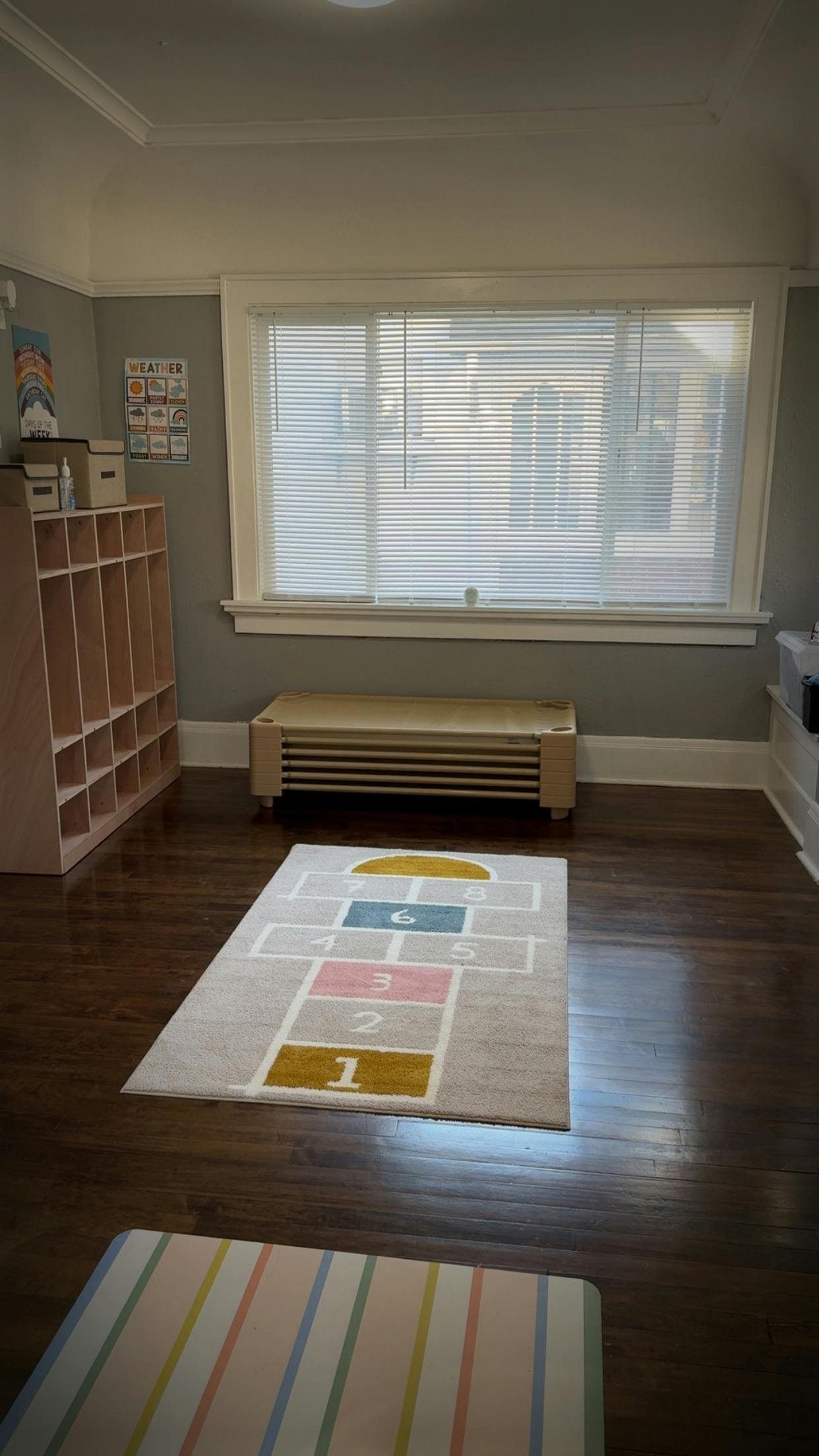 Playroom with a hopscotch rug on a wooden floor