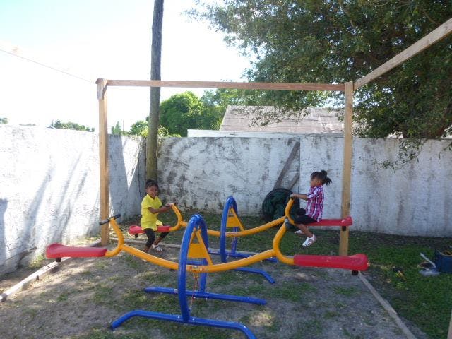 Two children on a seesaw in a playground