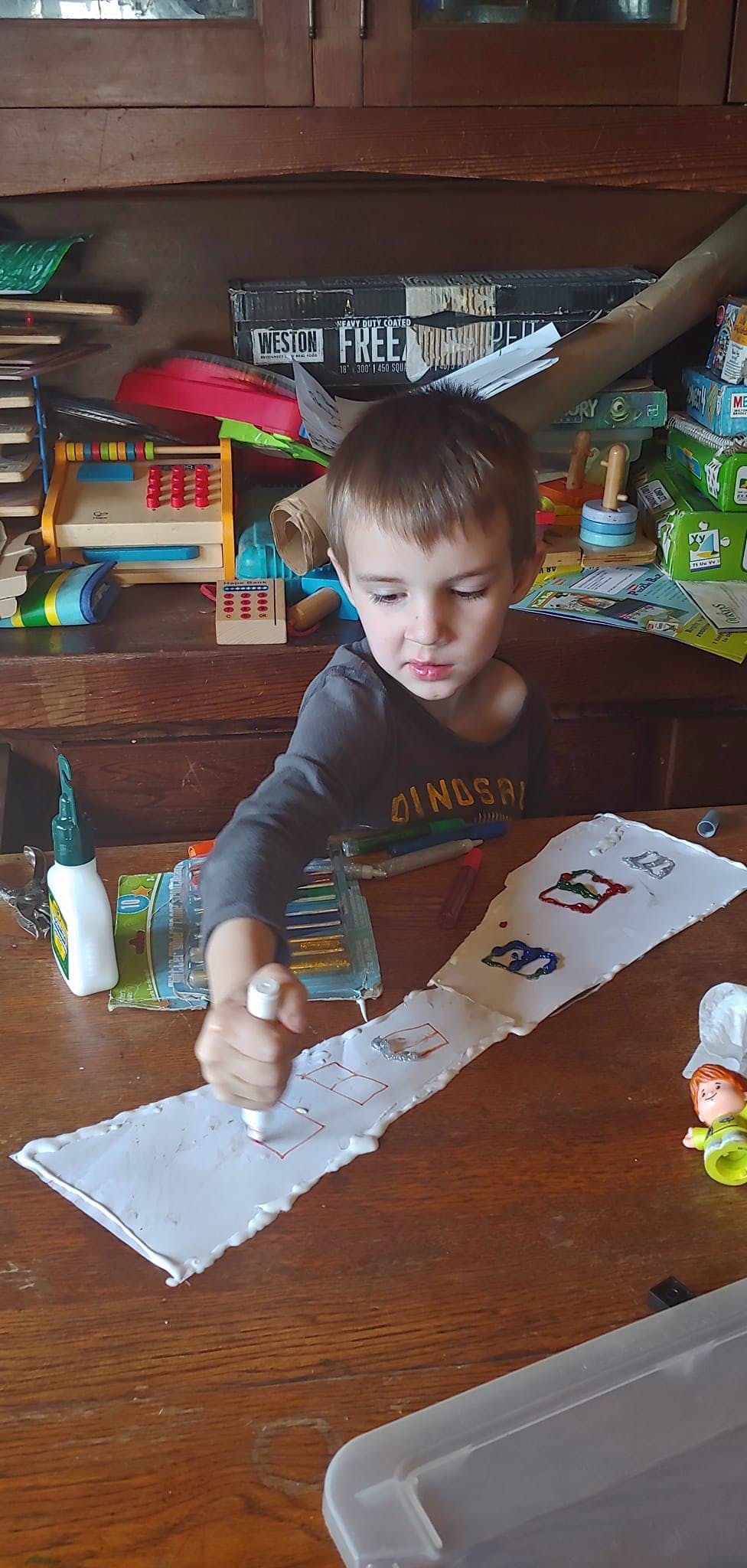 Child drawing on paper with a marker at a table