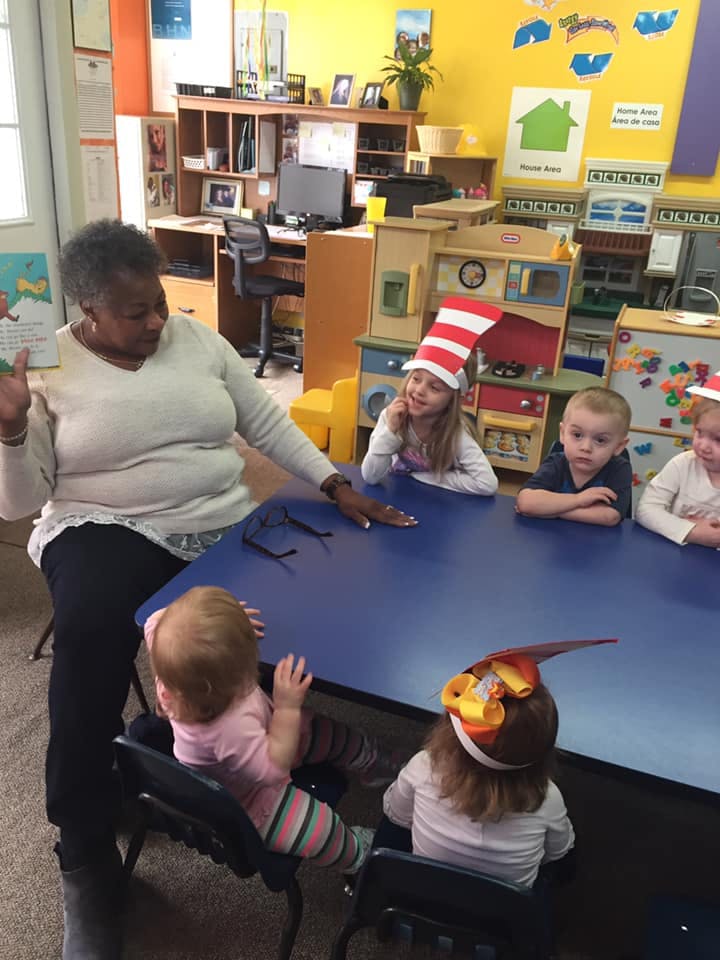 Adult and children sitting around a table in a classroom