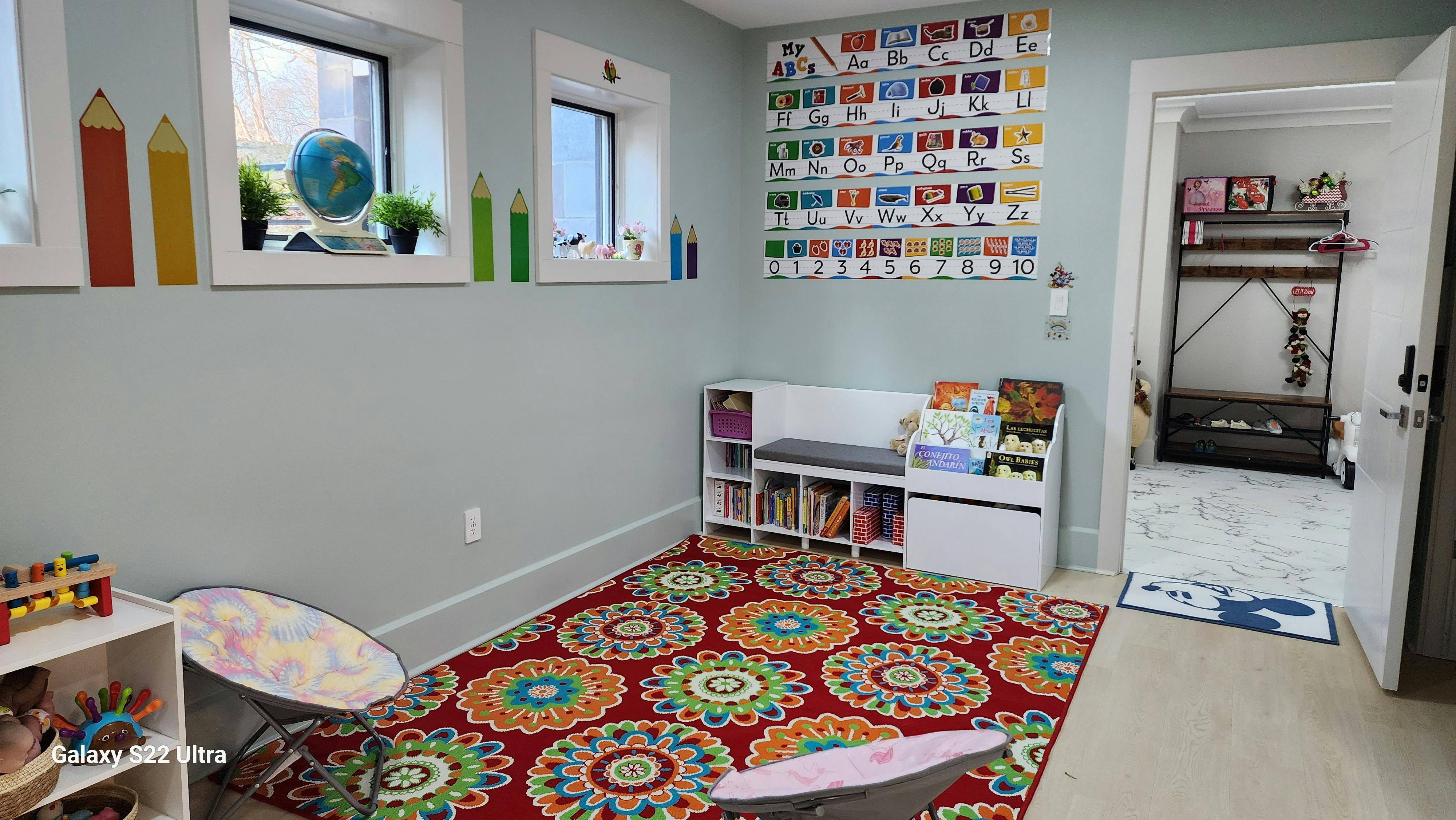 Playroom with colorful rug, windows, and storage shelves