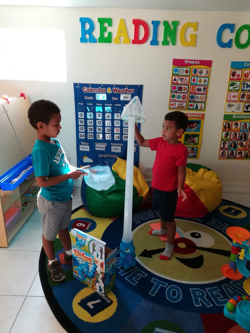 Two children playing with toys in a classroom