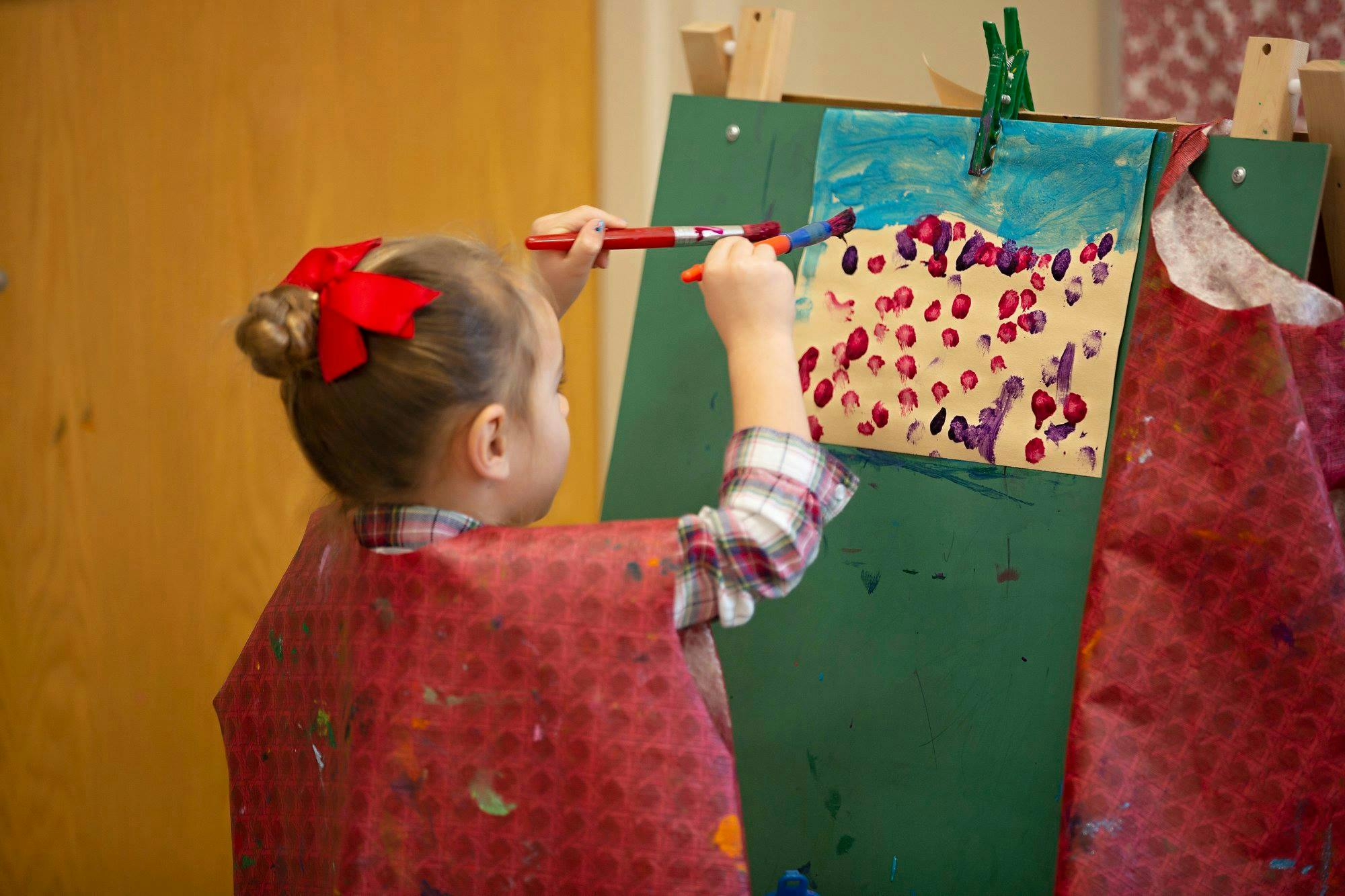 Child painting at an easel