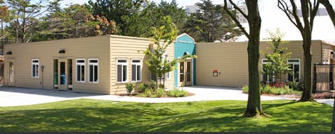 Single-story building with tan walls and white-framed windows