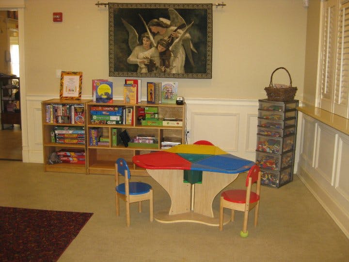 Children's play area with a colorful table, chairs, and bookshelves