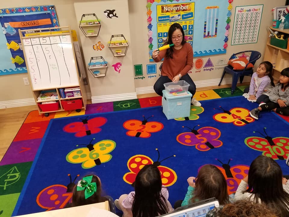 Adult leading an activity for children in a classroom