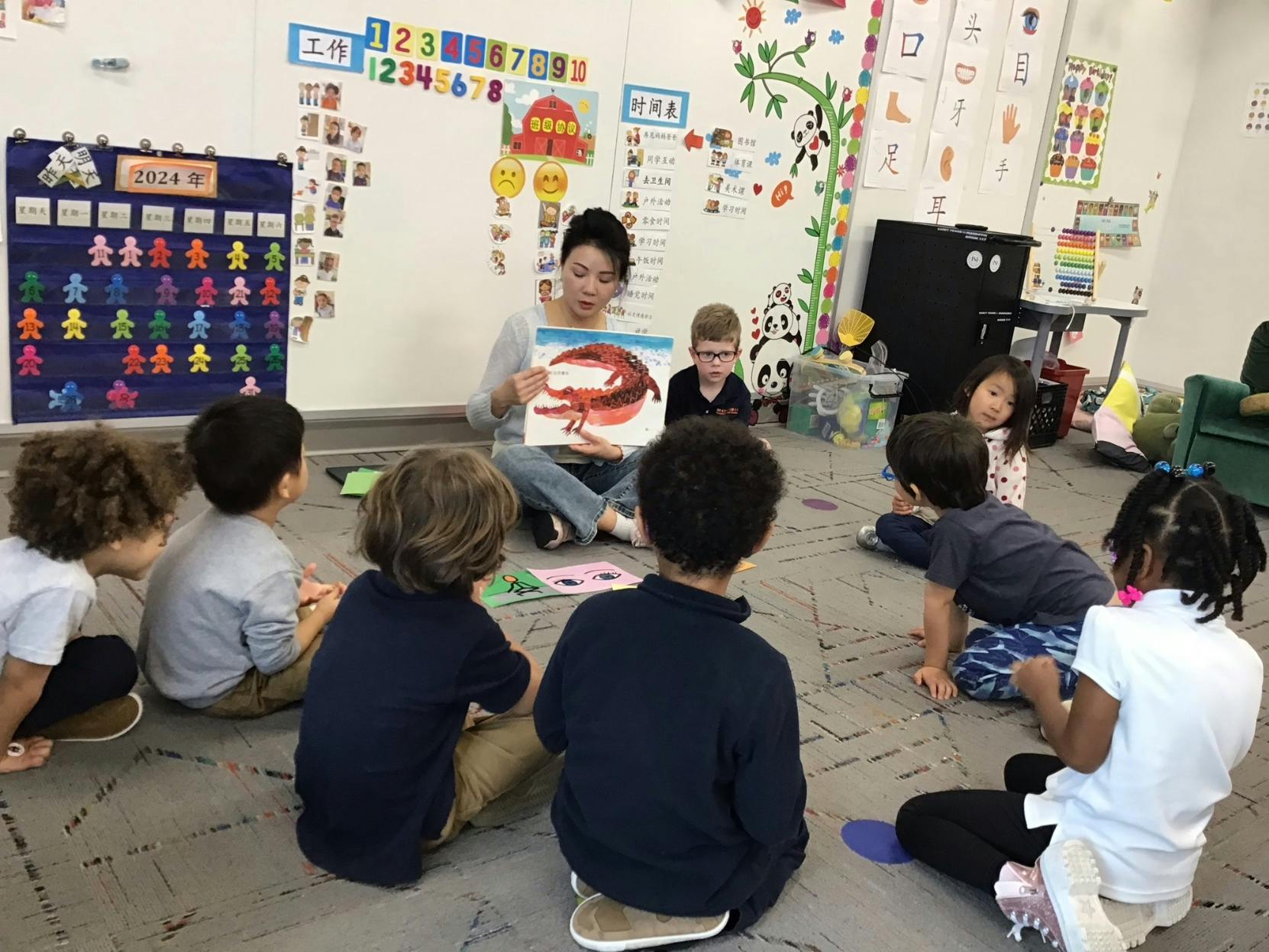 Adult reading a book to children in a classroom