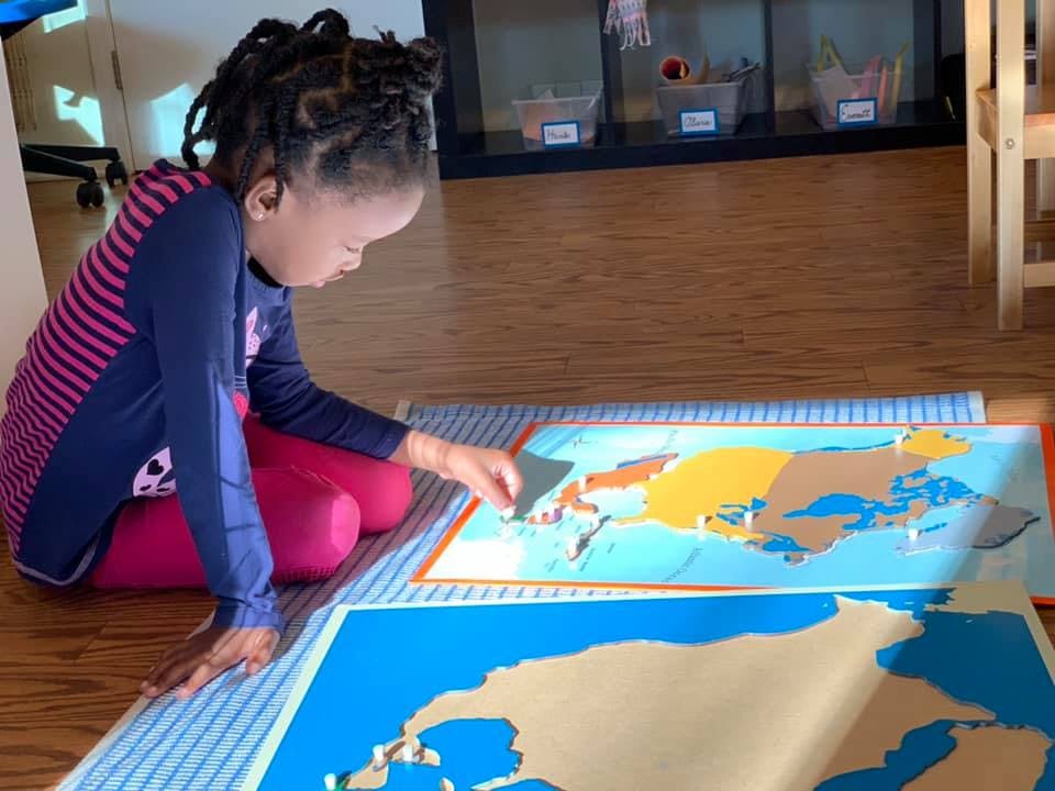 Child on floor working with a puzzle map