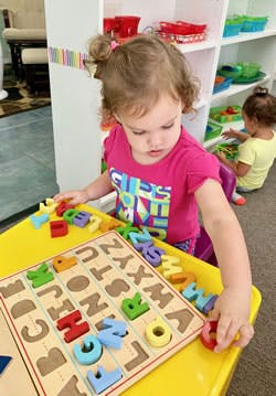 Child playing with an alphabet puzzle