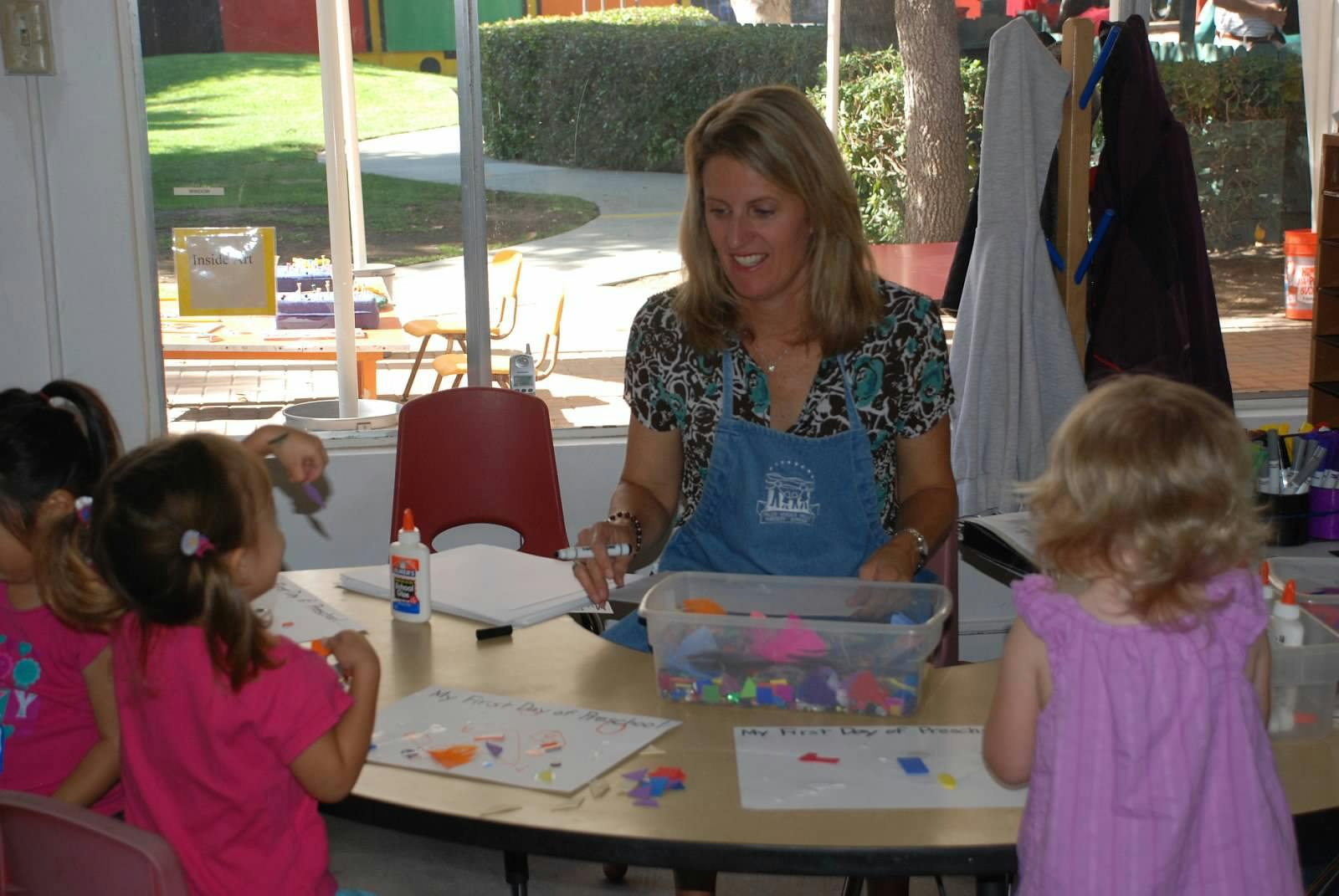 Adult and children at a table doing an art activity
