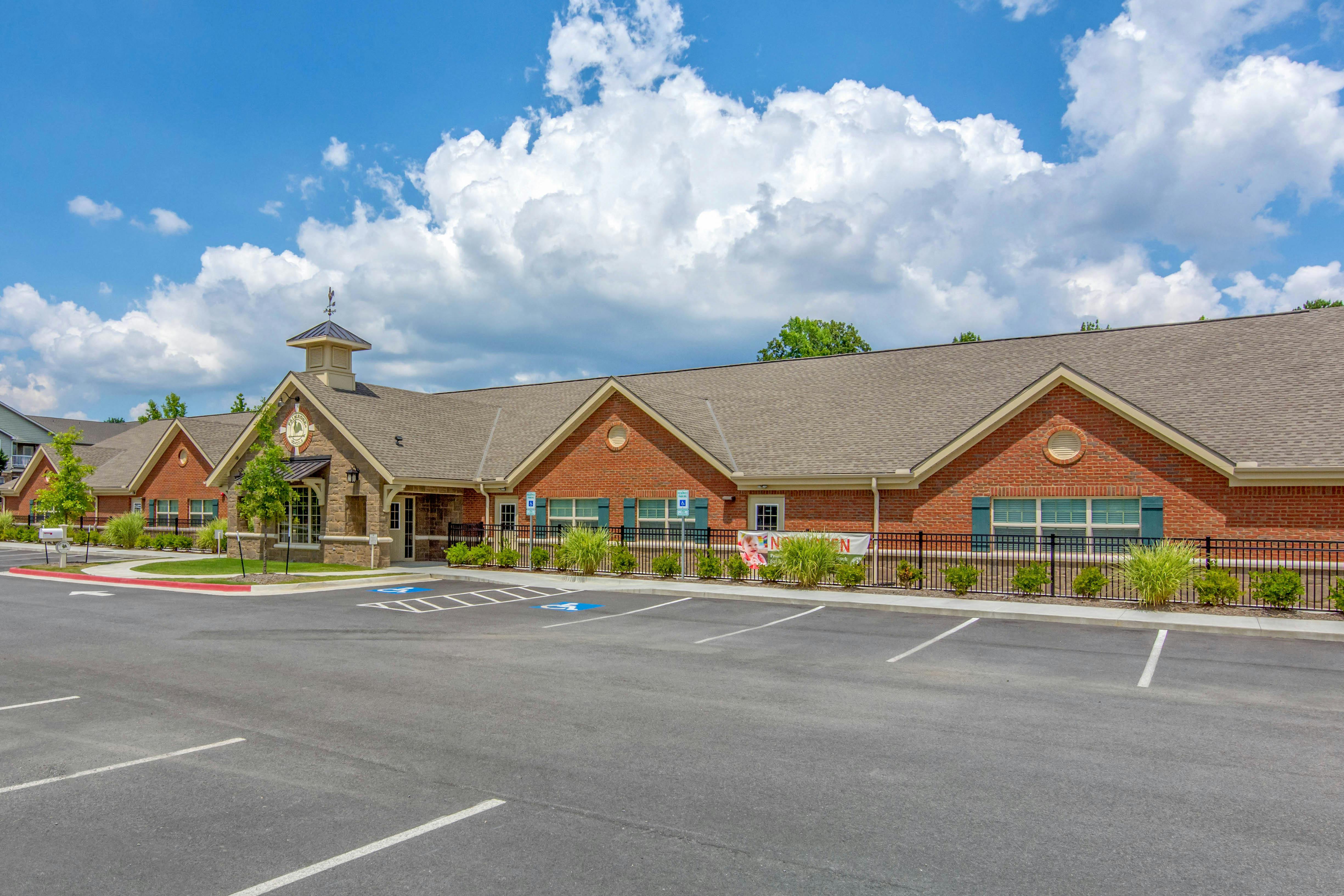 Brick building with a stone entrance, cupola, and adjacent parking lot