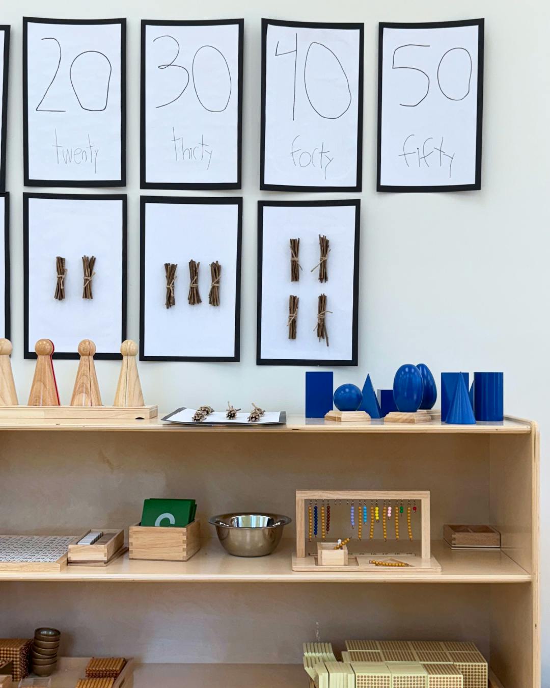 Classroom shelf with learning materials and number cards on the wall