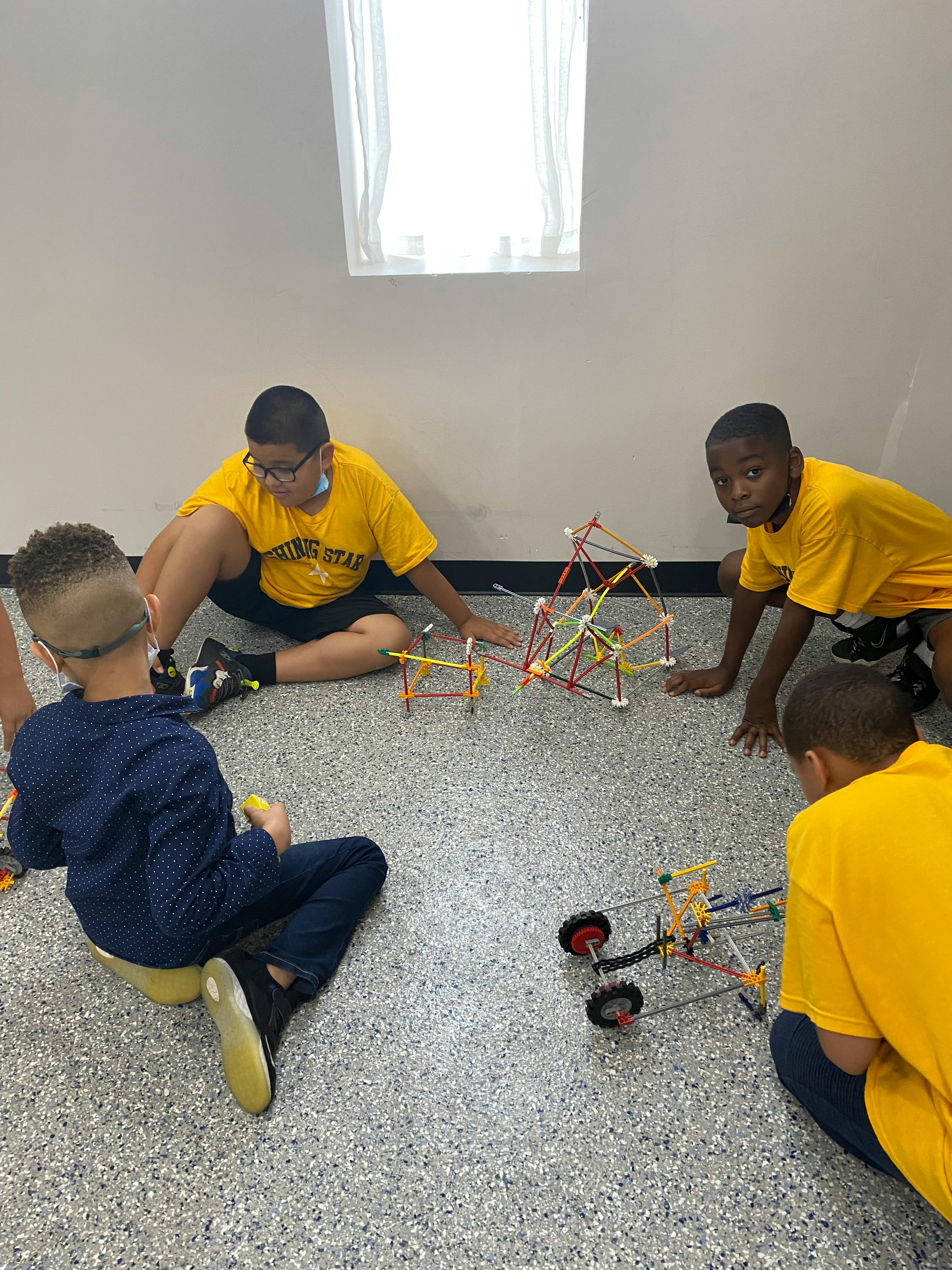 Children sitting on the floor building with colorful construction toys